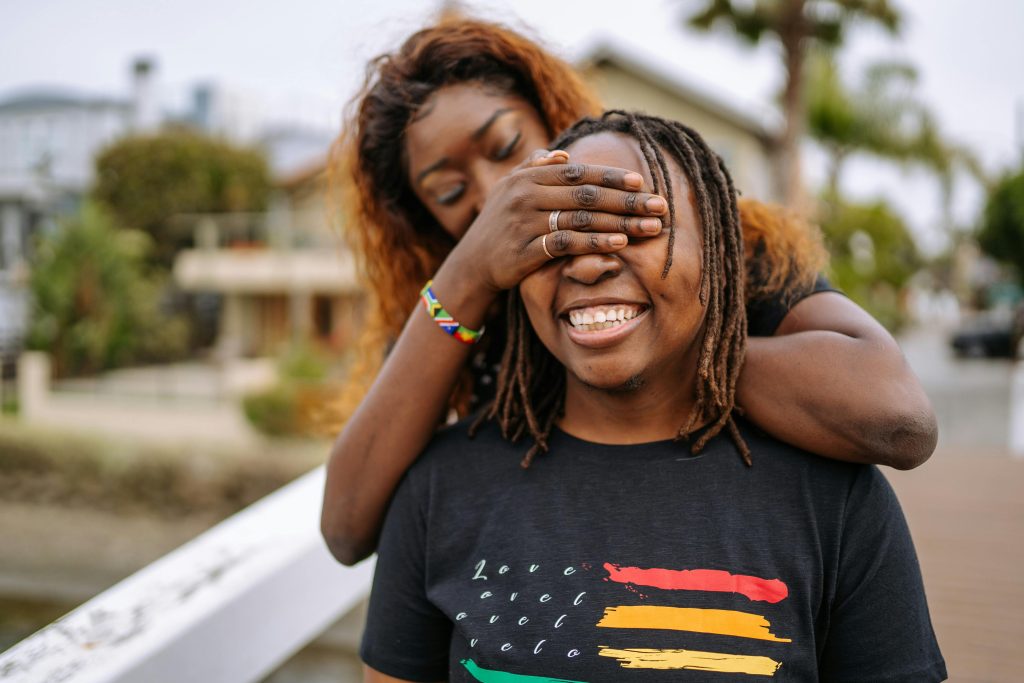 Two individuals playfully interacting outdoors, reflecting cultural sensitivity at Serengeti Wellness.